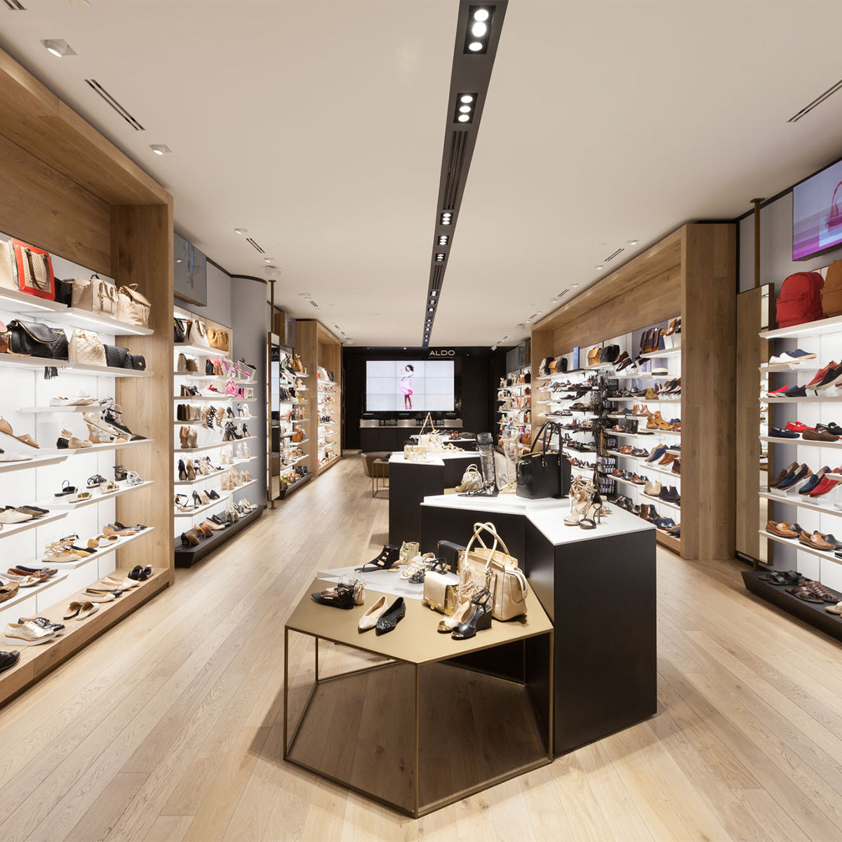 Modern shoe store interior with shelves displaying shoes and bags.