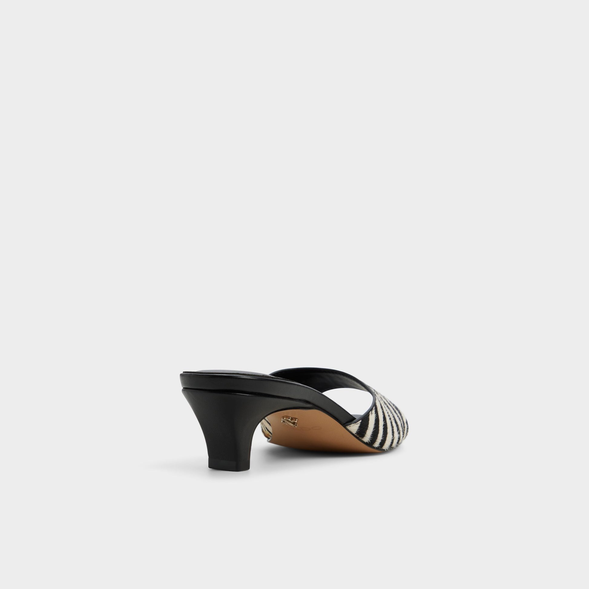 Three-quarter angle of White/Black Haeden Heeled mule's back side
