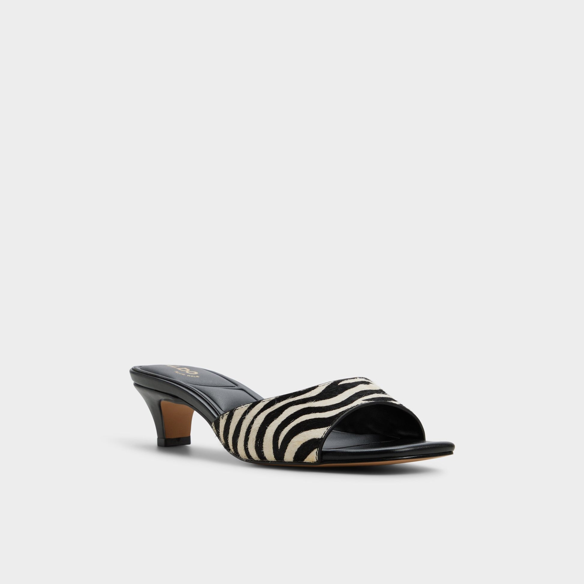 Three-quarter angle of White/Black Haeden Heeled mule's front side