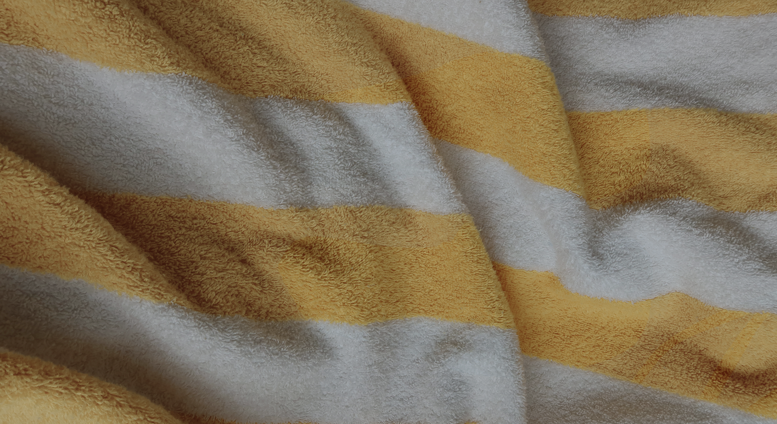 Zoom sur une serviette rayée jaune