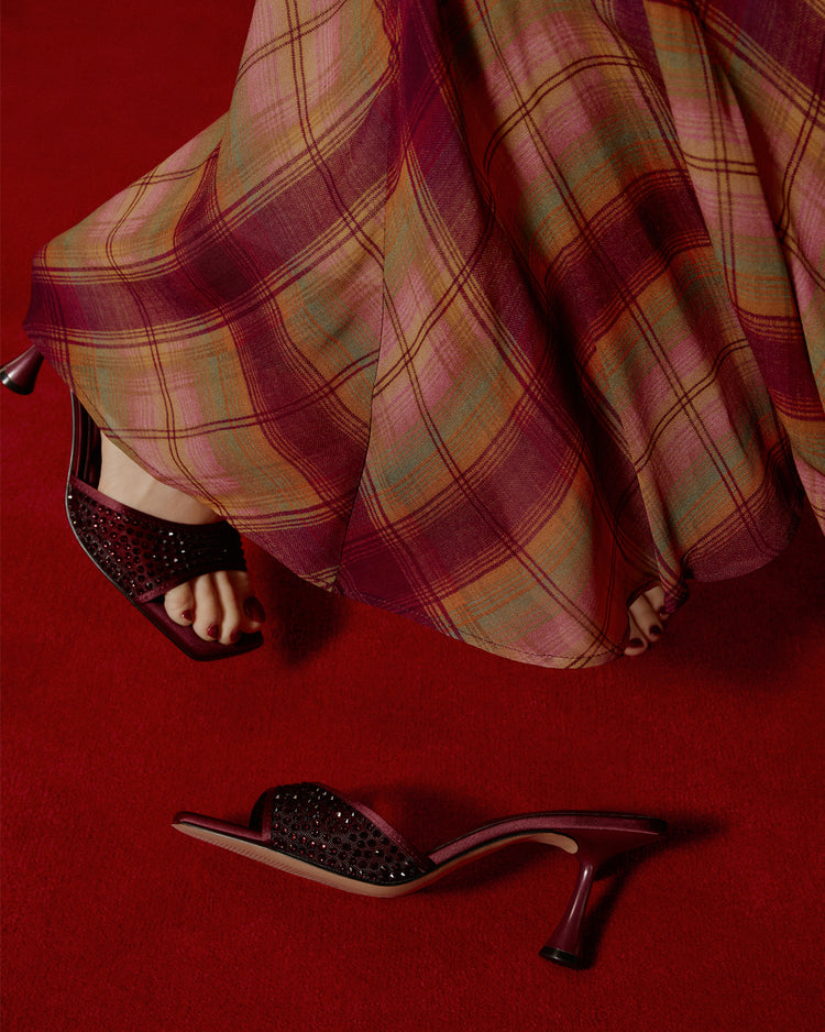 Plaid skirt and high-heeled shoes on a red background