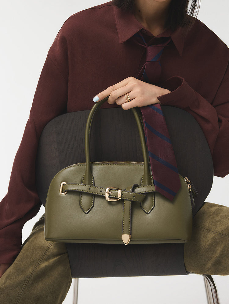 Person holding a green handbag with a white background