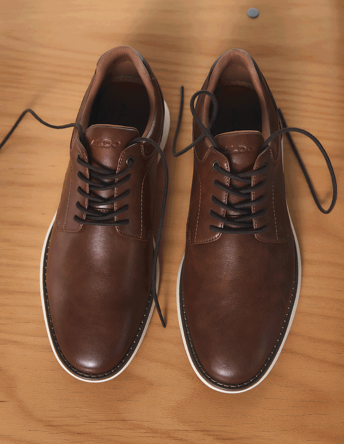 A GIF of brown casual shoes, a brown textured stiletto tall boot, a black chelsea boot and a woman standing in front of beige vintage car.