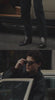A man steps out of a beige vintage car and leans casually against it, dressed in a black jacket, black pants, and sleek black western boots for a polished, effortlessly cool look.