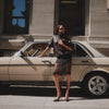 A GIF featuring a woman in a brown jacket, matching brown heels, and a brown clutch standing beside a beige vintage car. Alongside, a man is seated in a restaurant setting, paired with a close-up shot of a woman holding a black clutch accented with a gold ring detail.