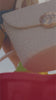 woman at the beach with textured handbag and sandals with colorful buckets on the sand.