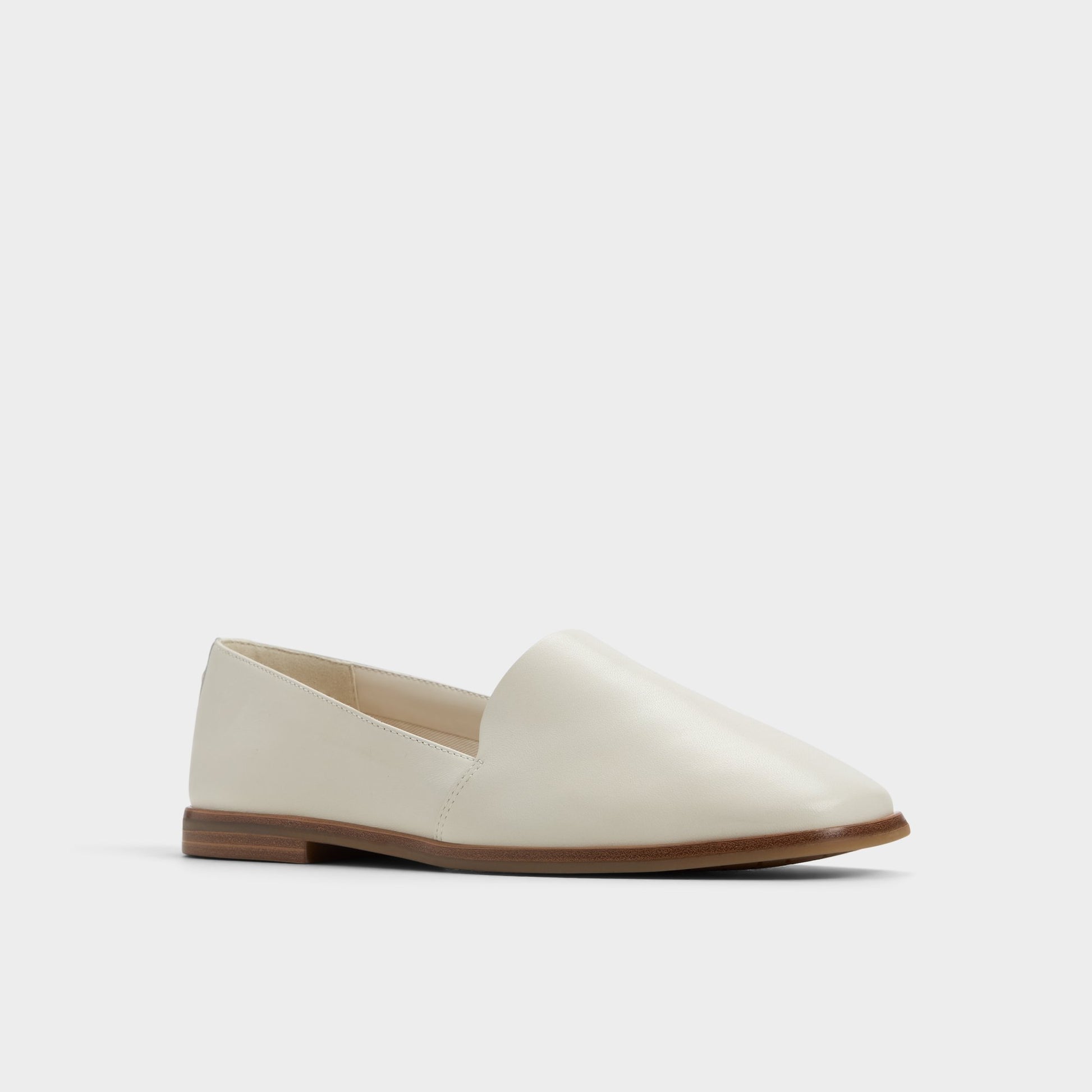 Three-quarter angle of White/Bone Caraelia Slip-on's front side