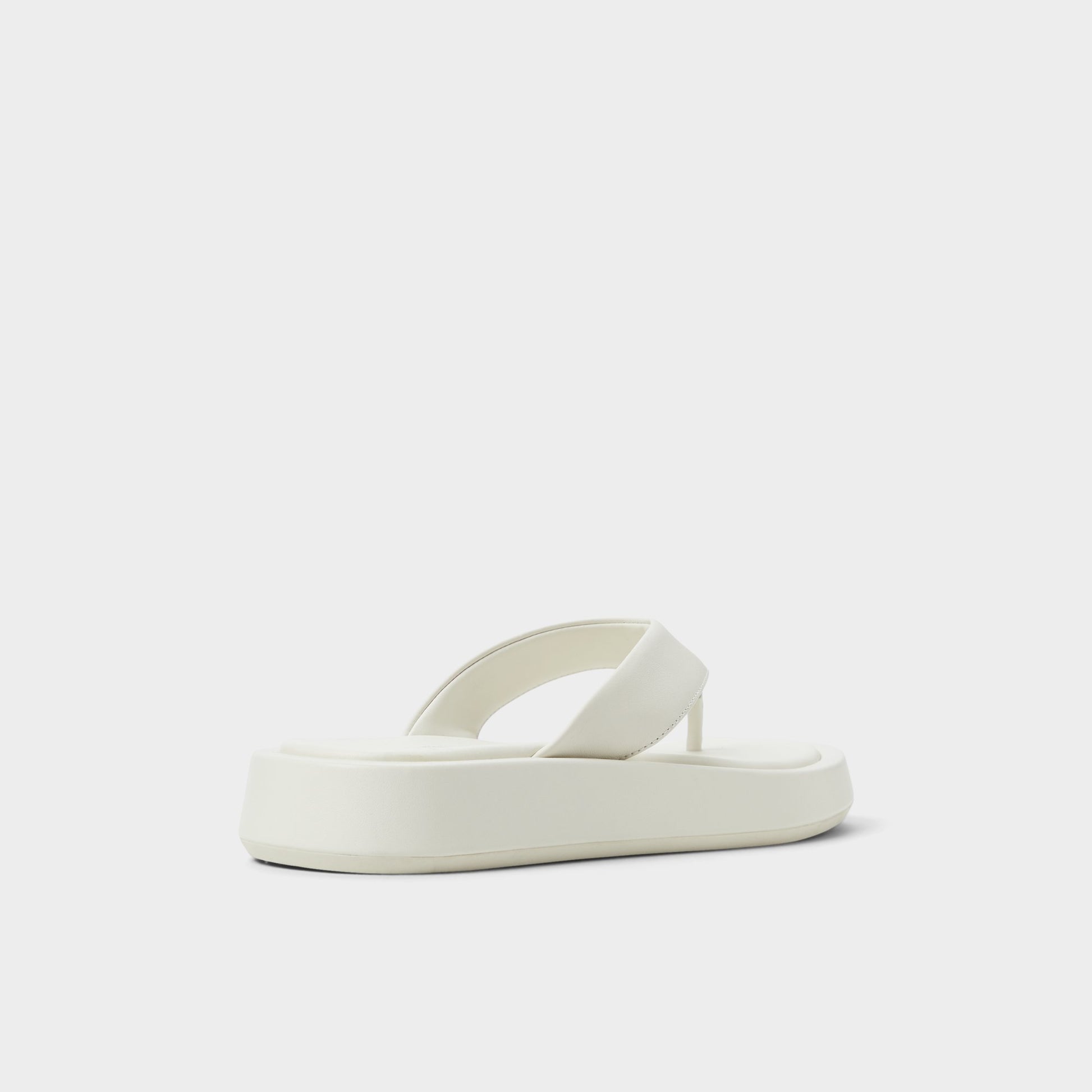 Three-quarter angle of White/Bone Grettle Flip flop's back side