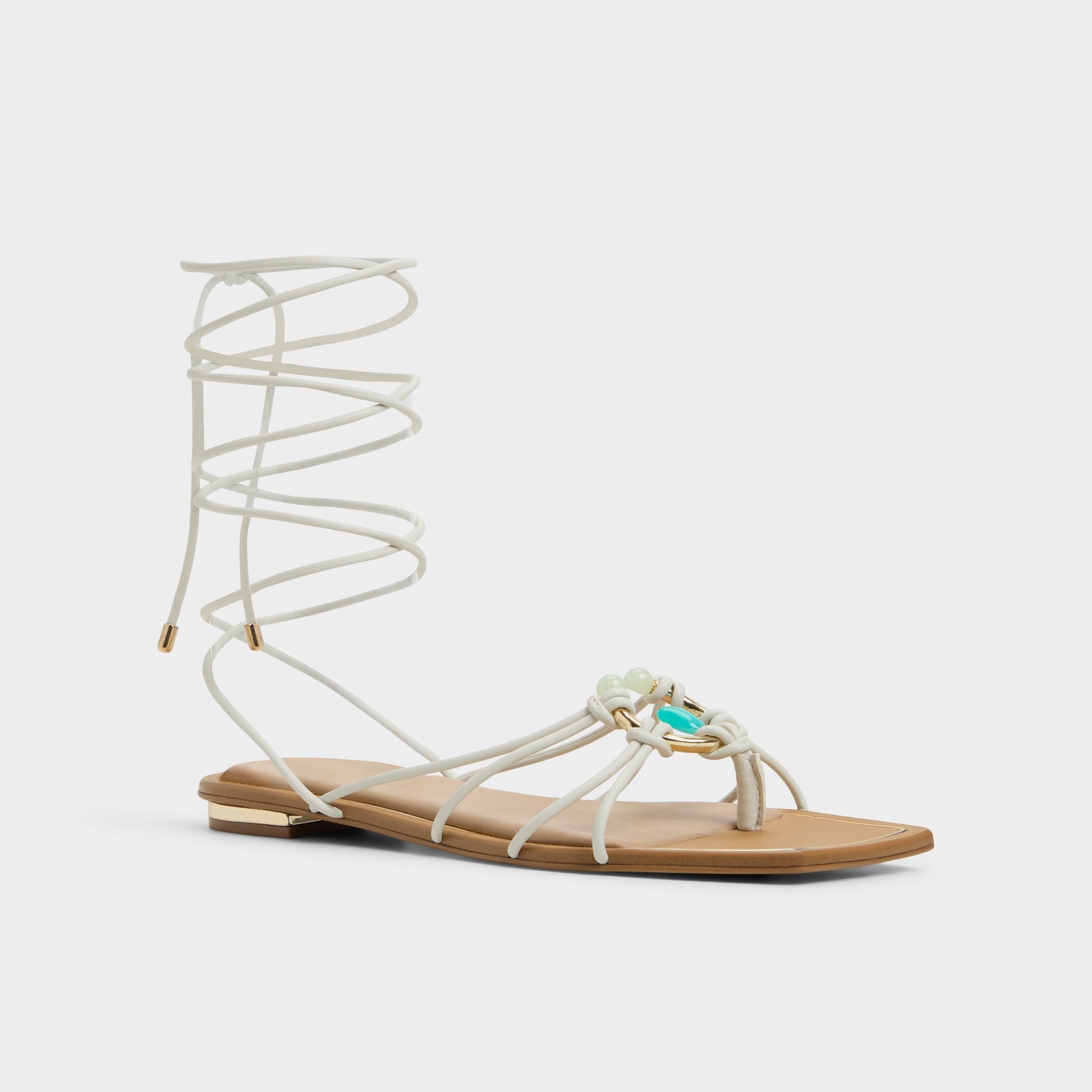 Three-quarter angle of White/Bone Nirena Strappy flat sandal's front side