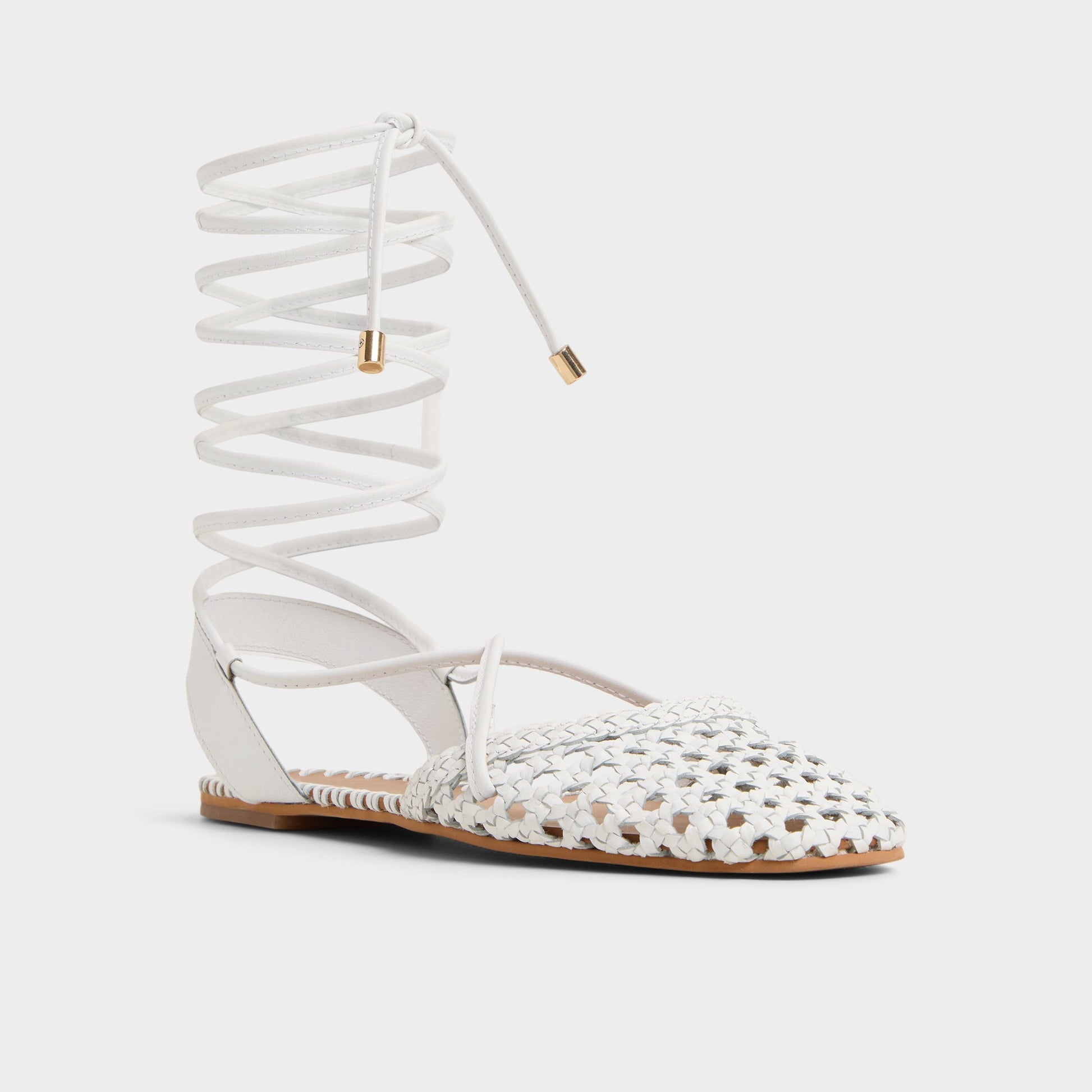 Three-quarter angle of White/Bone Dragostee Strappy flat sandal's front side