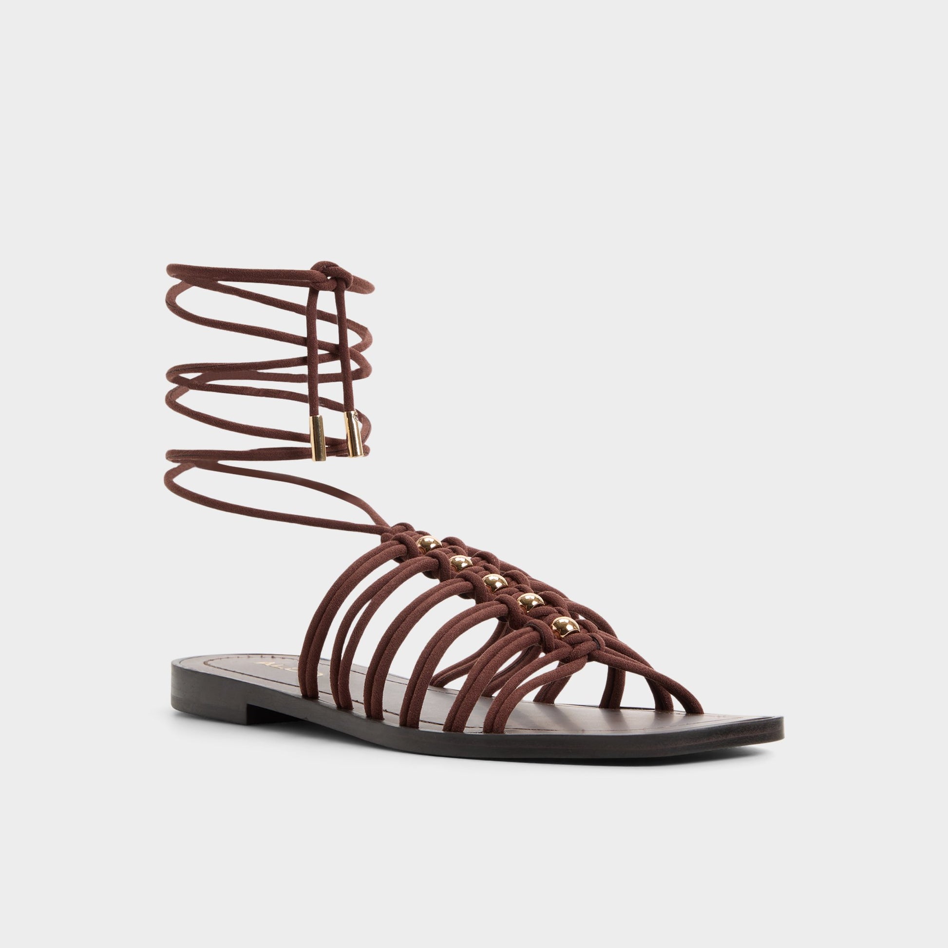 Three-quarter angle of Dark brown Unoma Strappy flat sandal's front side