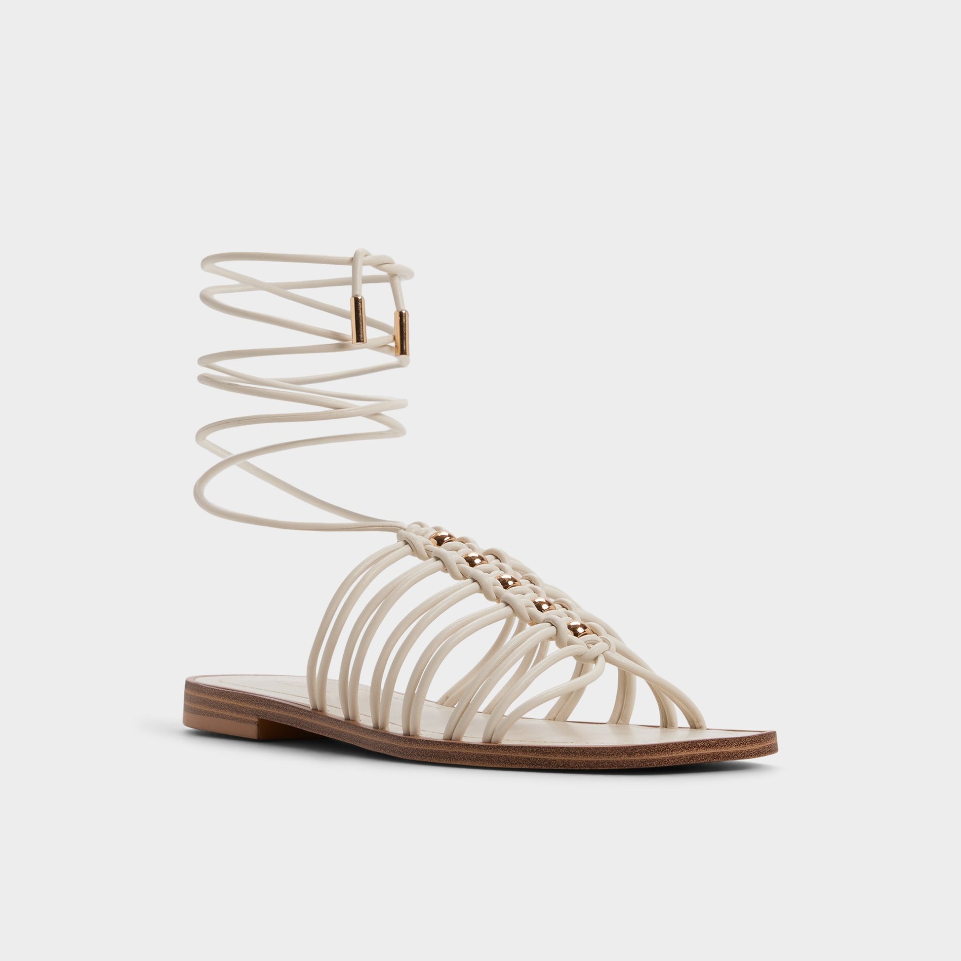 Three-quarter angle of White/bone Unoma Strappy flat sandal's front side