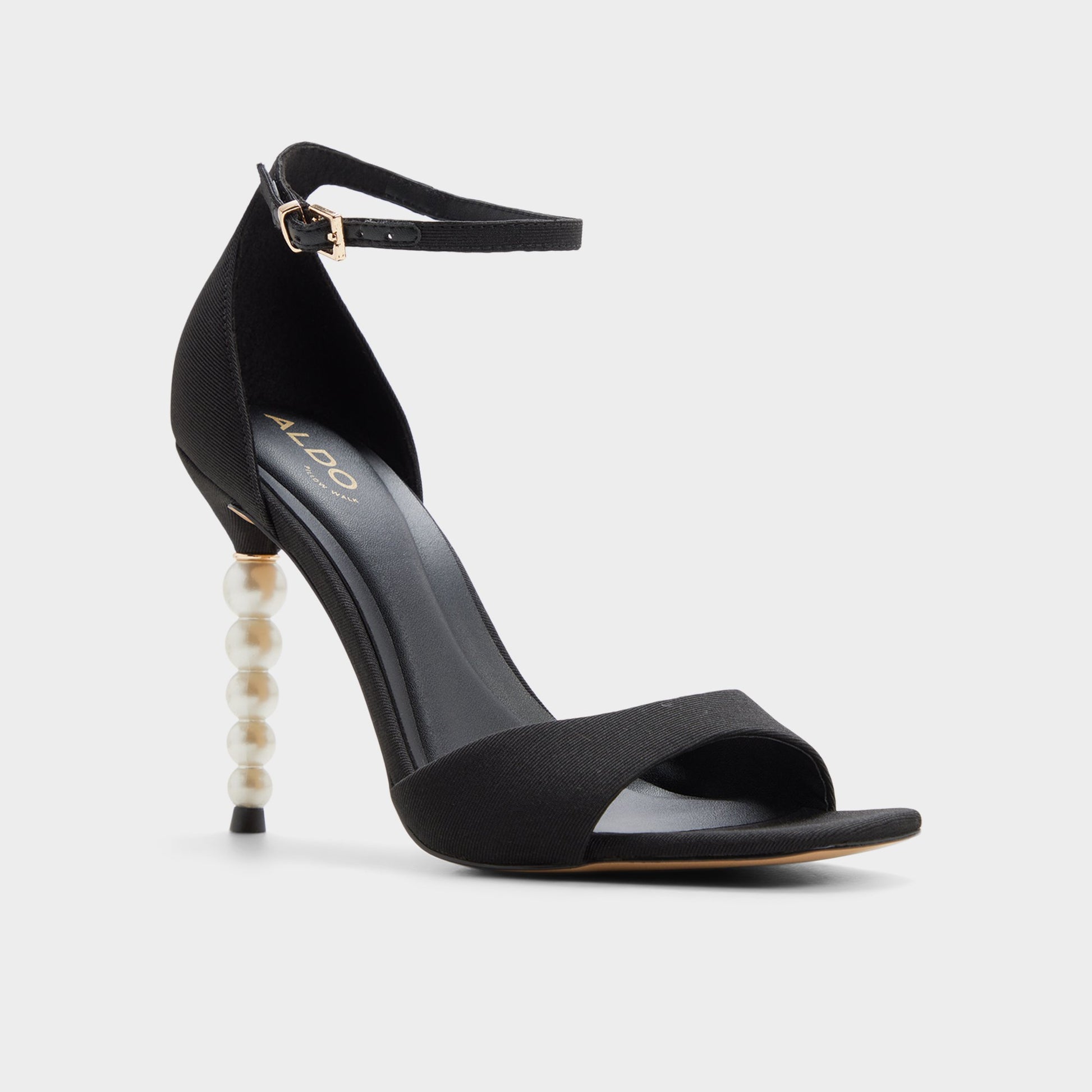 Three-quarter angle of Black Pearletta Strappy heeled sandal's front side