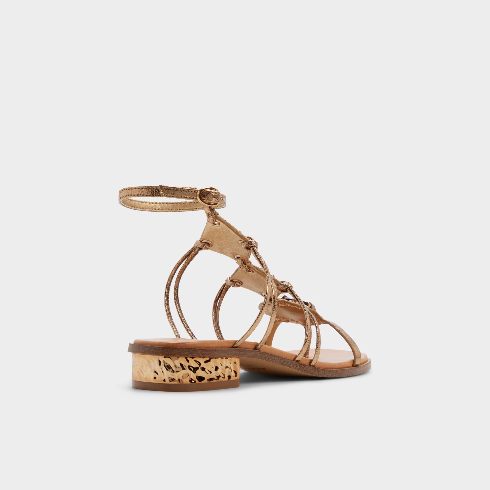 Three-quarter angle of Gold Sandjewel Gladiator sandal's back side