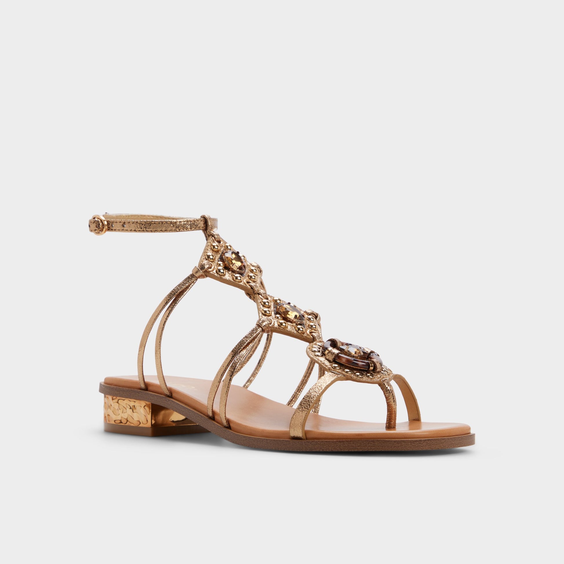 Three-quarter angle of Gold Sandjewel Gladiator sandal's front side