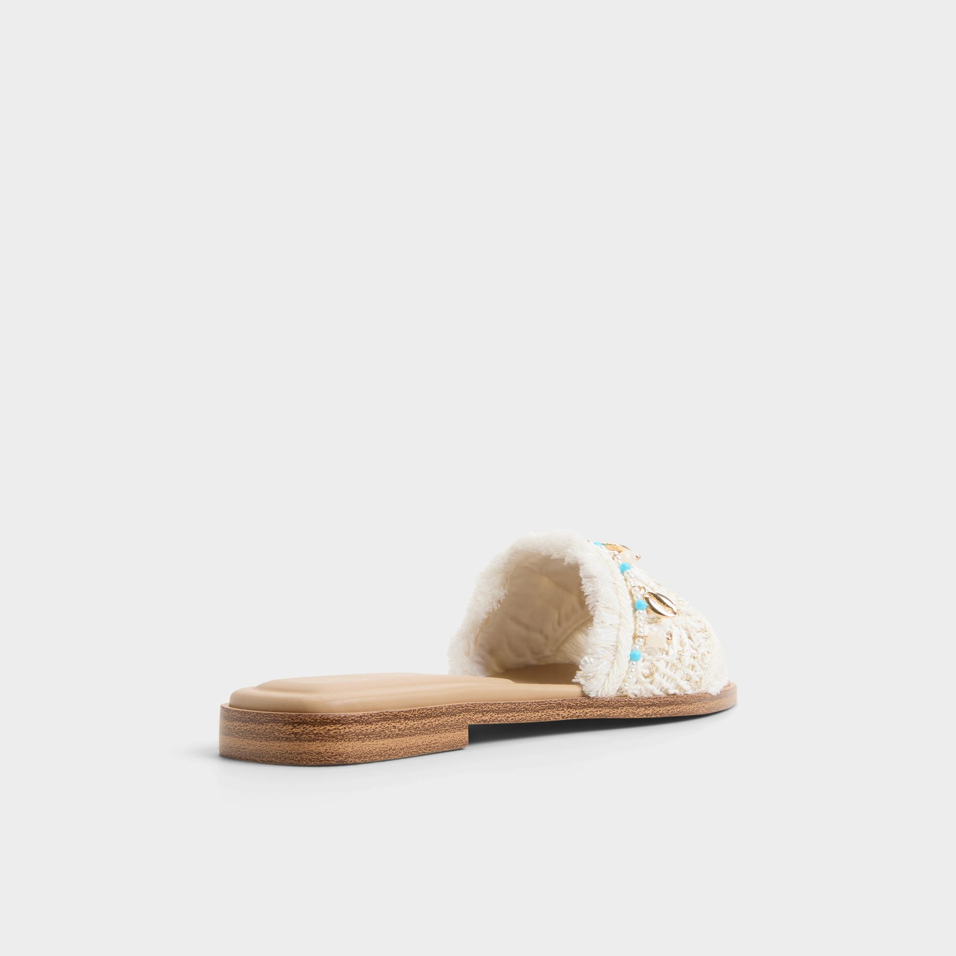 Three-quarter angle of White/bone Aurana Slide sandal's back side