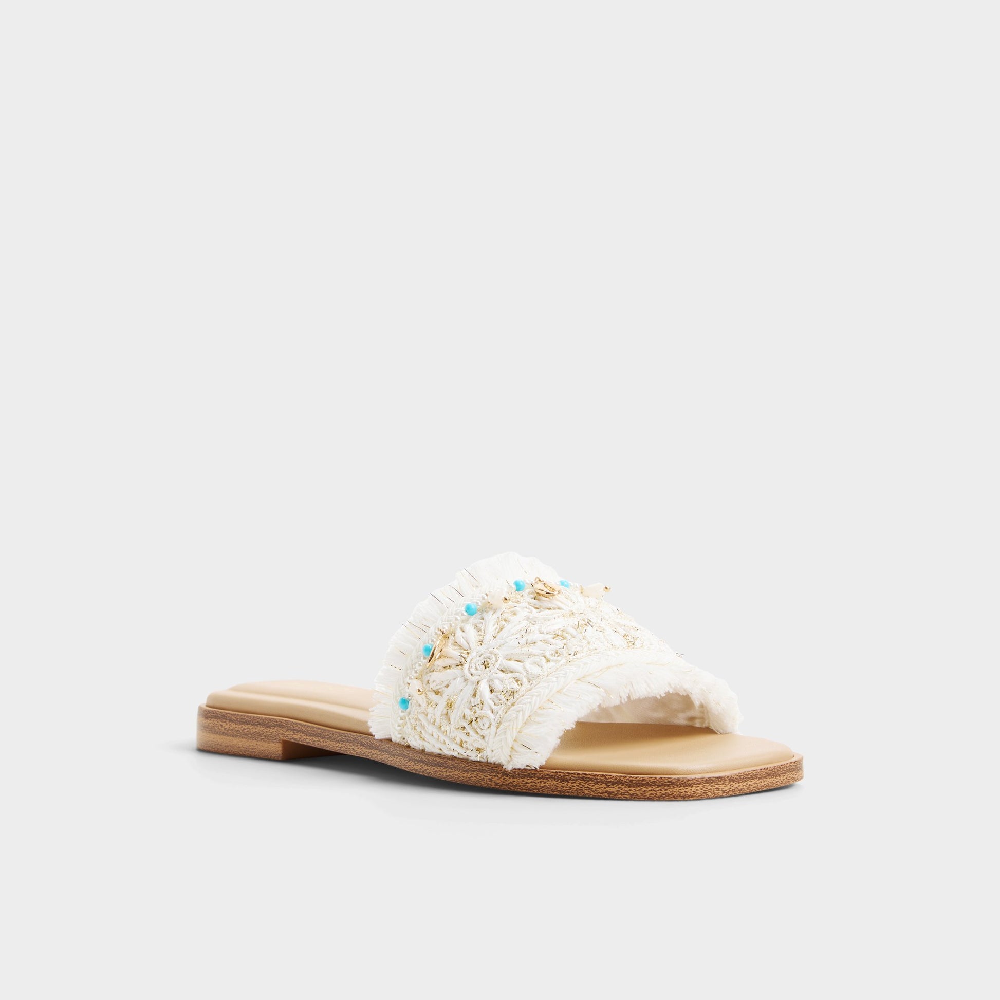 Three-quarter angle of White/bone Aurana Slide sandal's front side