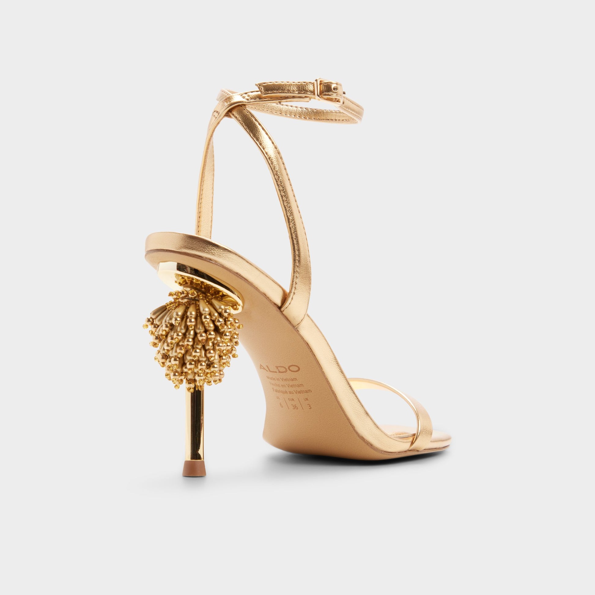 Three-quarter angle of Gold Aurorae Strappy heeled sandal's back side